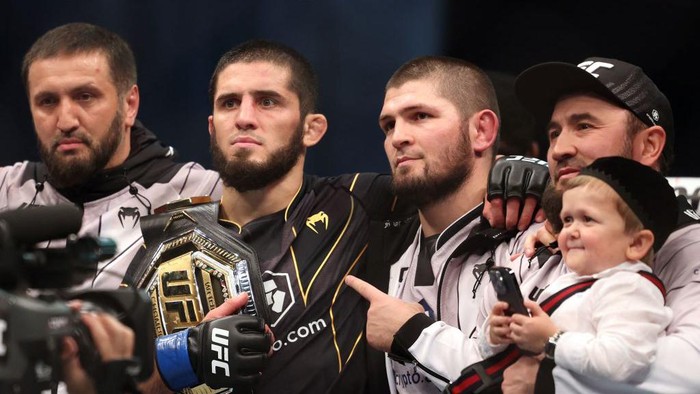 Islam Makhachev bersama Khabib Nurmagomedov dan tim setelah Islam menangi sabuk juara (AFP via Getty Images/GIUSEPPE CACACE)