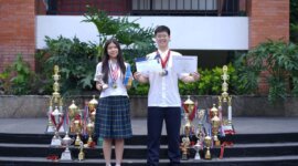 Ava Mikayla Emmanoelle Kasih (14) dan Sean Levi Danuseputra (15) tampak berfoto sambil mengenakan medali, dikelilingi oleh berbagai piala, serta memegang sertifikat penghargaan dari kompetisi yang pernah mereka juarai. (Dok. Sekolah Pelita Harapan LV)